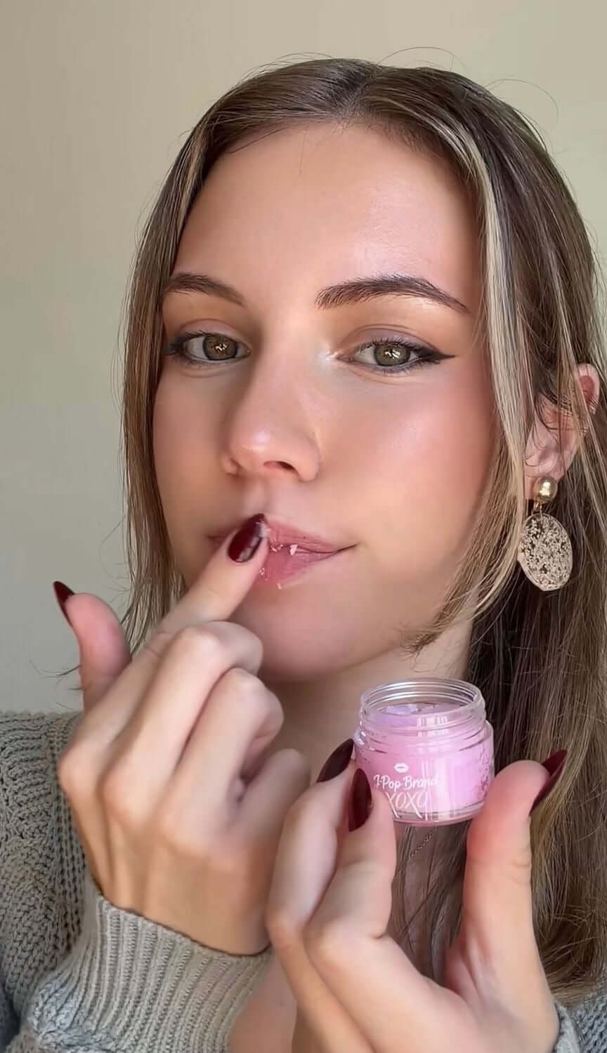 Model applying lip product from the Strawberry Bomb S-Bomb Elevate Bundle with fresh strawberry scent.
