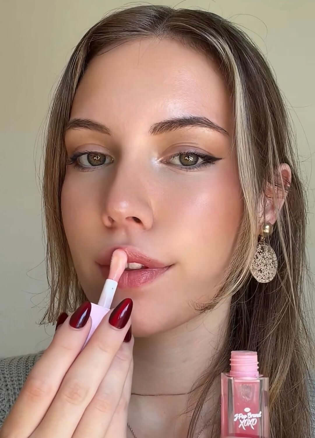 Strawberry Bomb S-Bomb Elevate Bundle display with a model applying lip gloss.
