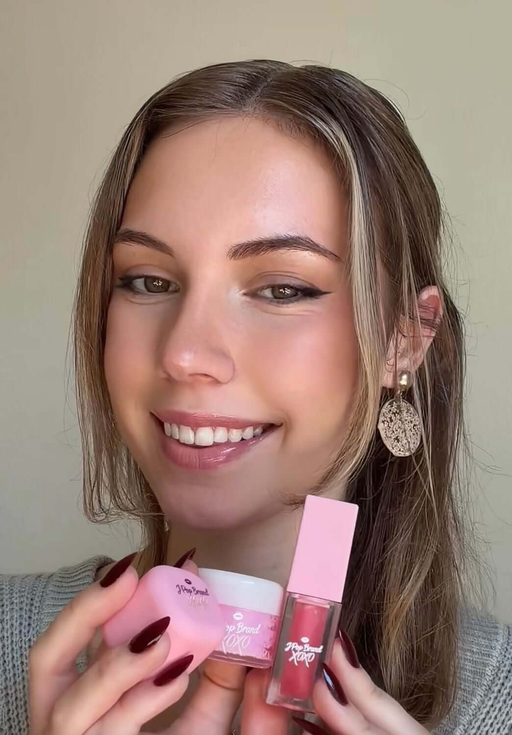 Strawberry Bomb S-Bomb Elevate Bundle featuring skincare products and a smiling model showcasing glowing skin.